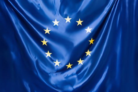 close up of blue european union flag with yellow stars