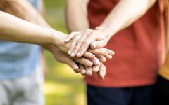 Unity Concept. Group Of Mature People Joining Hands Together While Standing Outdoors