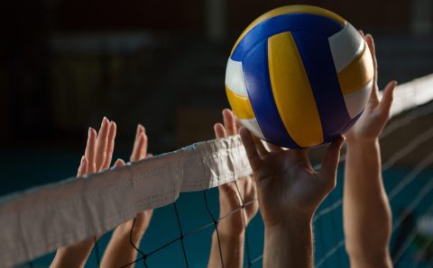 Cropped hands of players practicing volleyball at court