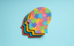 Paper human heads with colorful puzzle pieces on a light backgro