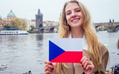 woman with an appetite eats a traditional The Charles Bridge and wawing with flag