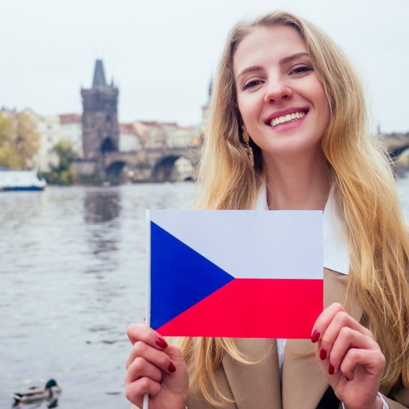 woman with an appetite eats a traditional The Charles Bridge and wawing with flag