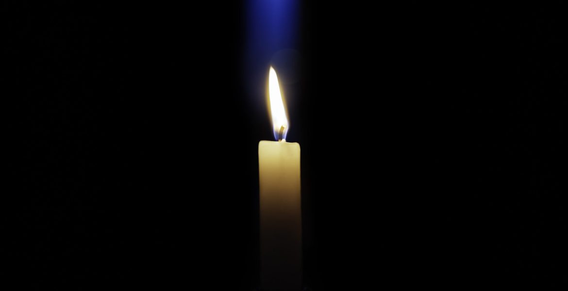 Candle is burning on a dark background