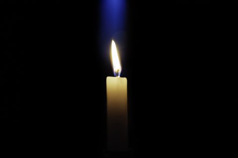 Candle is burning on a dark background
