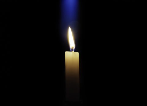 Candle is burning on a dark background